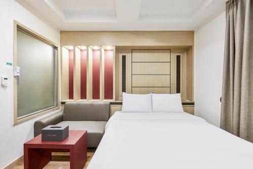 スウォンにあるHotel Avenue Suwonのベッドとソファのあるホテルの部屋