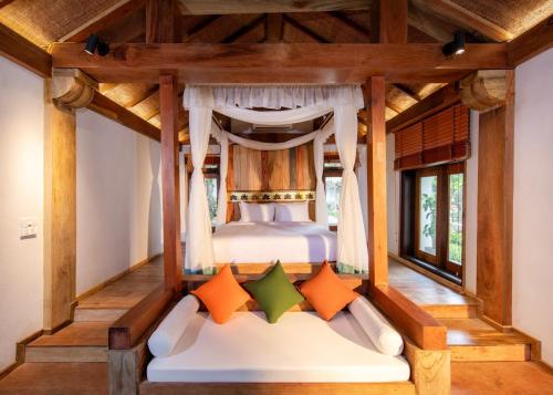 a bedroom with a canopy bed in a room at Hang Mua Ecolodge in Ninh Binh