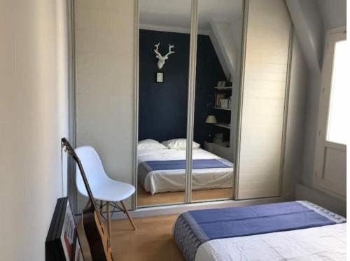 - une chambre avec un miroir, un lit et une chaise dans l'établissement Apartment terrace - Eiffel tour vue, à Paris