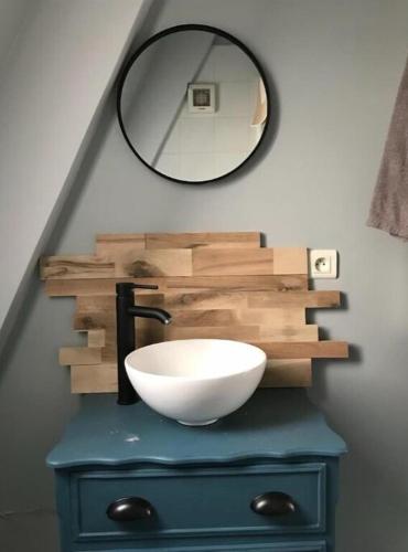 La salle de bains est pourvue d'un lavabo et d'un miroir sur une commode. dans l'établissement Apartment terrace - Eiffel tour vue, à Paris