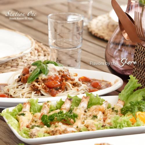 - deux assiettes de nourriture sur une table avec des nouilles dans l'établissement Station One Beach Resort, à El Nido