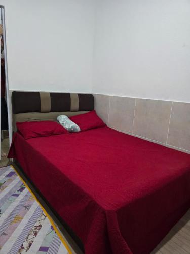 a large bed with a red comforter in a room at Apto J com cozinha em Macapá in Macapá