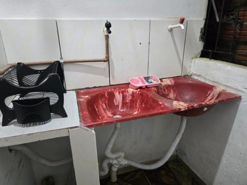 a red sink with a pink phone on top of it at Apto J com cozinha em Macapá in Macapá