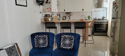 a kitchen with two blue chairs and a counter at Apartamento San Jose Tacna 2 habitaciones in Tacna