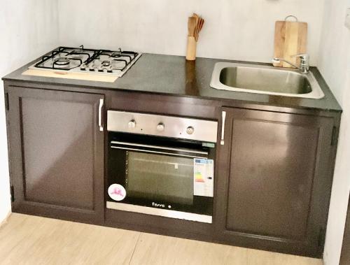 a kitchen with a stove and a sink at Fortune Villas in Trou dʼ Eau Douce