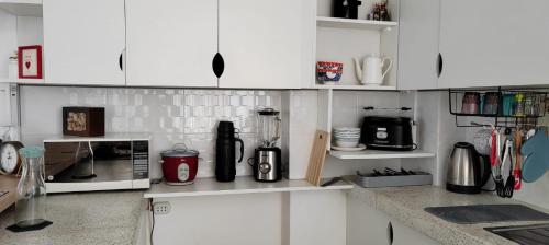 a kitchen with white cabinets and a counter with appliances at Apartamento San Jose Tacna 2 habitaciones in Tacna