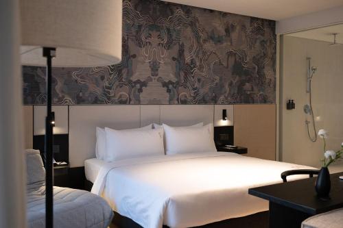 a hotel room with a large white bed and a mirror at December Hotel in Nha Trang