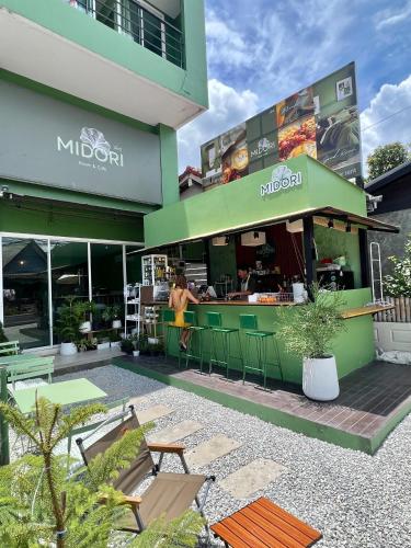 Ban Saiyuan (1)にあるMidori Rawai Hotelのレストラン前に立つ女