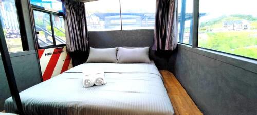 a small bed in a room with windows at Campod Resort @ Cameron Highlands in Cameron Highlands