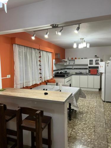 a kitchen with orange walls and a table and chairs at Departamento La Paz in La Falda