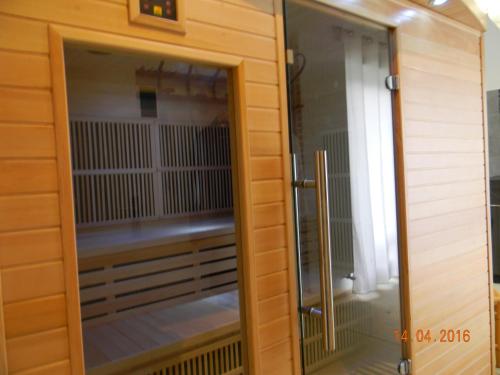 a wooden cabinet with a glass door of a bird cage at La Ferme Pateli in Courouvre