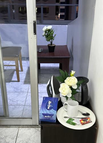 a table with a cup of coffee and flowers on it at Abu Dhabi Phenomenal in Abu Dhabi