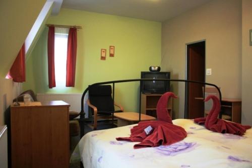 a bedroom with a bed with red towels on it at Pension Zlata Noha in Bratislava