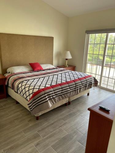 a bedroom with a large bed and a window at Hermosa casa entera cerca de la Presa del Rejón in Chihuahua
