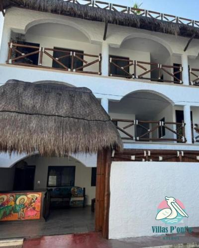 a building with a thatch roof and a patio at Hotel Villas Ponto Holbox in Holbox Island
