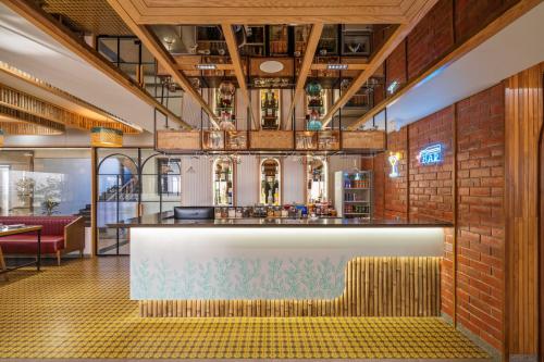a bar in a restaurant with a brick wall at The Lemon Grass Hotel in Gandhinagar