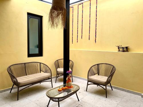 a group of chairs and a table in front of a building at Casa Monarca in Oaxaca City