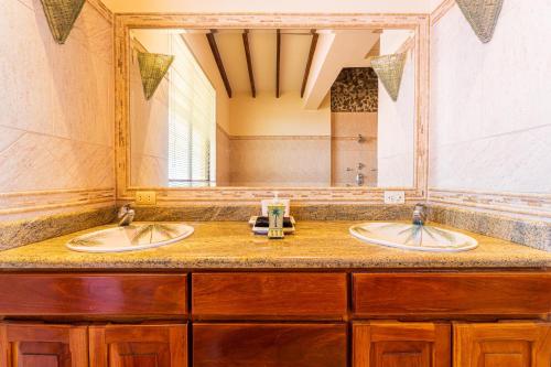 a bathroom with two sinks and a large mirror at Paraiso Presidential 20 -Ocean View Penthouse And Digital Nomad Haven in Playa Flamingo
