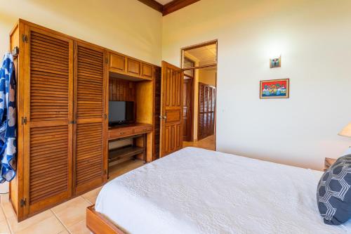 a bedroom with a bed and a flat screen tv at Paraiso Presidential 20 -Ocean View Penthouse And Digital Nomad Haven in Playa Flamingo