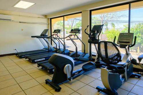 a gym with several treadmills and elliptical machines at Paraiso Presidential 20 -Ocean View Penthouse And Digital Nomad Haven in Playa Flamingo