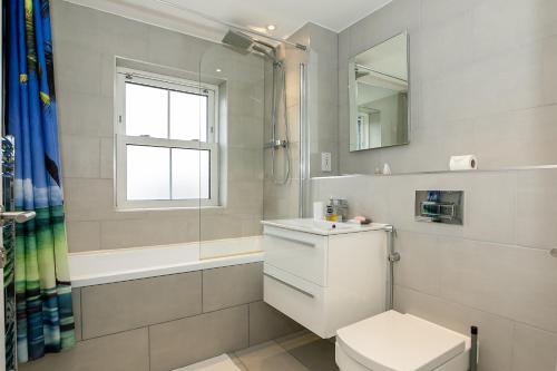 ein Badezimmer mit Toilette und Waschbecken und einem Fenster in der Unterkunft Cosy 3 Bedroom Home Next to Bicester Village! in Bicester