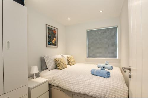 ein Schlafzimmer mit einem Bett, auf dem ein Teddybär liegt in der Unterkunft Cosy 3 Bedroom Home Next to Bicester Village! in Bicester