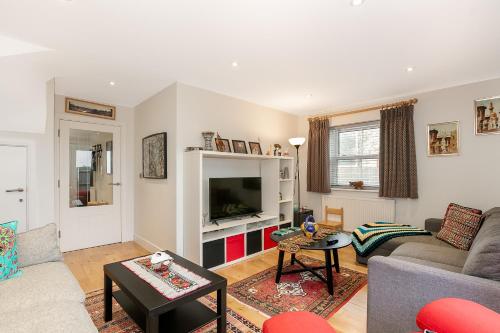 a living room with a couch and a tv at Cosy 3 Bedroom Home Next to Bicester Village! in Bicester