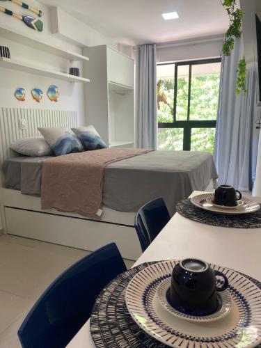 a bedroom with two beds and two tables with hats on them at Flat na beira-mar de Tamandaré in Tamandaré
