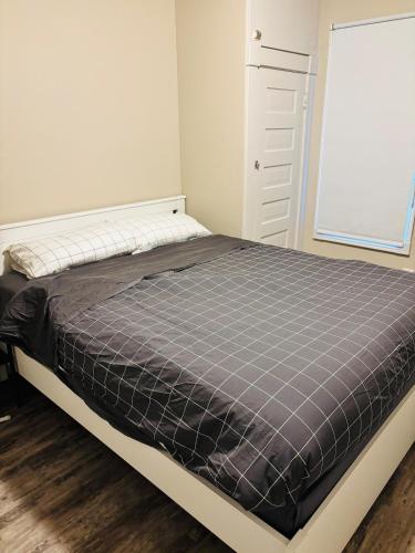 1 cama en un dormitorio con colchón gris en Upper Floor 1 Bedroom Suite with Parking, en Calgary