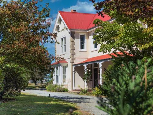 a large white house with a red roof at Ardross House in Amberley