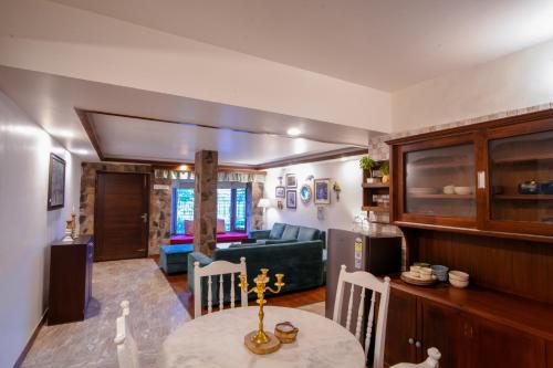 a kitchen and living room with a table and a couch at Woodburry Mansion, Cozy Nainital Homestay in Nainital