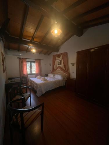 a bedroom with two beds and a table and chairs at Hotel Il Pietreto in Colle Val D'Elsa