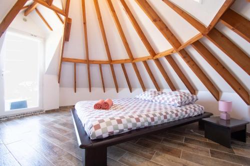 un lit dans une chambre avec un plafond en bois dans l'établissement Moulin de Treflez I Plage et Calme, à Crozon