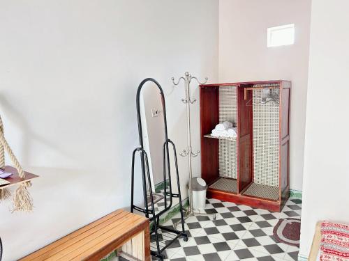 a room with a bird cage on a checkered floor at Cô Tô Lương Chi in Quang Ninh