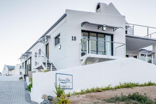 a white house with a sign in front of it at Forever Blue in St Helena Bay