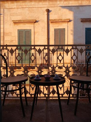 a table and chairs on a balcony in front of a building at Palazzo delle favole in Ostuni