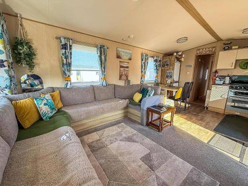 a living room with a couch and a table at Lovely 6 Berth Caravan With Decking To The Side In Heacham Ref 21040E in Heacham
