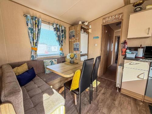 a living room with a couch and a table in a caravan at Lovely 6 Berth Caravan With Decking To The Side In Heacham Ref 21040E in Heacham
