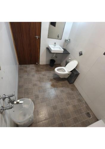 a bathroom with a toilet and a sink at Hotel Shubhashree Comfort in Bijāpur