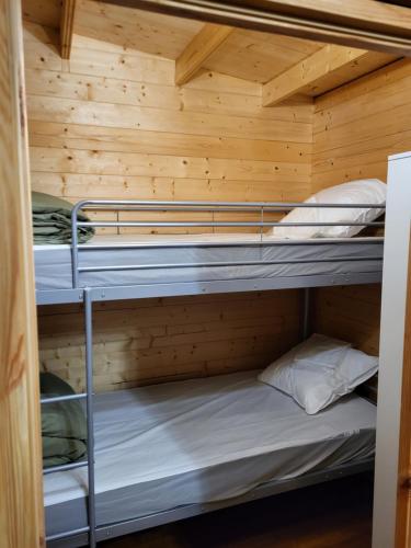 une chambre avec deux lits superposés dans une cabine dans l'établissement Camping D'étival, à Étival-Clairefontaine