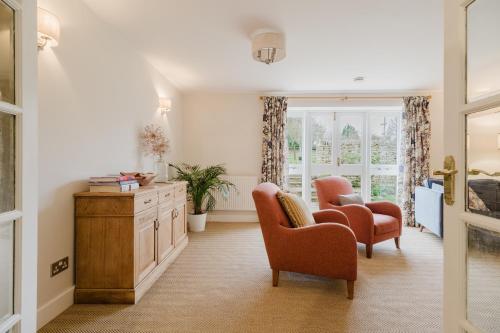 a living room with two chairs and a dresser at Country Cottage in the Heart of the Cotswolds! in Farmington