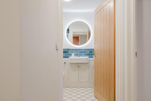 a bathroom with a sink and a mirror at Country Cottage in the Heart of the Cotswolds! in Farmington