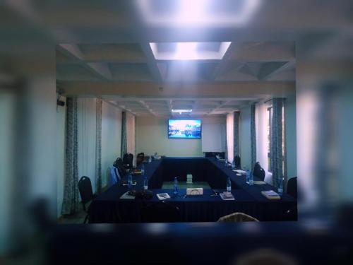 a room with tables and chairs and a projection screen at Lukenya Alkebu Resort in Nairobi