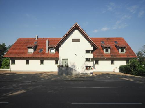a large white building with red roofs at Landhotel Waldheim in Pliezhausen