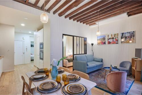 un salon avec une table et un canapé bleu dans l'établissement Sublim apartement Saint Germain des Prés, à Paris