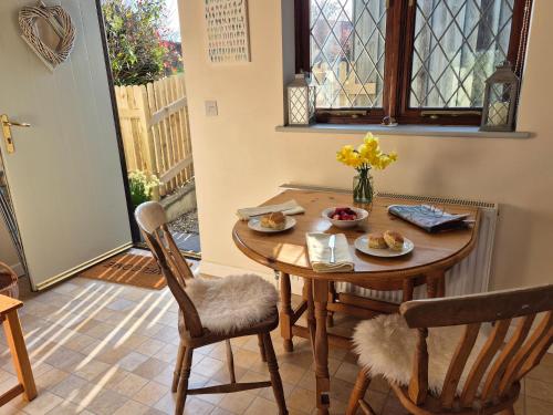 a table with plates of food on it in a room at Lovely Little Garden Cottage, Tamar Valley, Cornwall in Stoke Climsland
