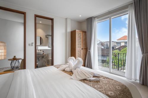スミニャックにあるVilla Umabell Villa Seminyakの窓のある大きなベッドのある寝室