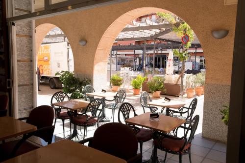 an empty patio with tables and chairs in a restaurant at Hotel Plaça in Sant Feliu de Guíxols