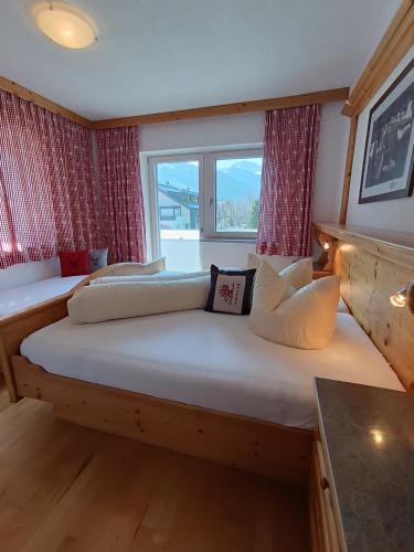 a bedroom with two beds and a large window at Schweinberger Sixtus in Aschau