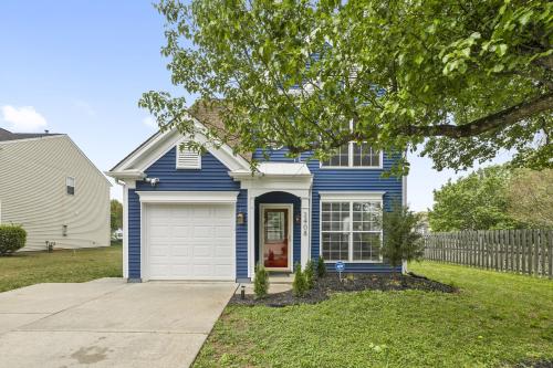 a blue house with a white garage at 3BR Family Retreat with Modern Comforts in Charlotte